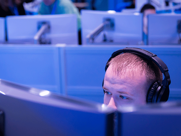 Man looking at a computer screen wearing headphones